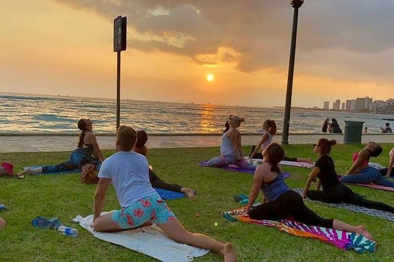 Yoga sur la plage et au coucher du soleil sur le front de mer de Waikiki avec Diamondhead en toile de fond